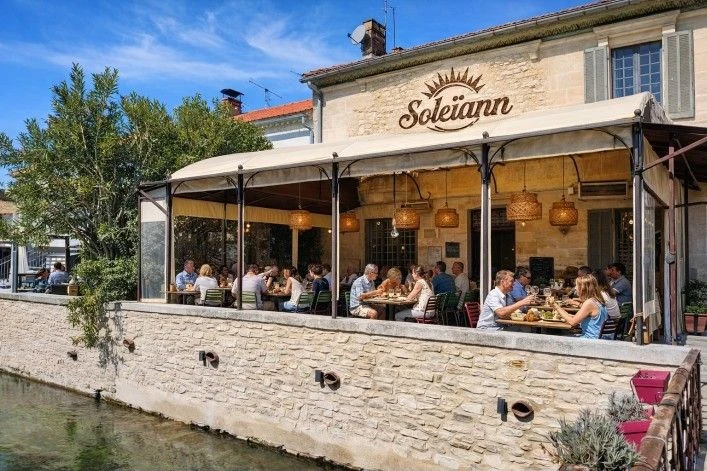La façade en pierre et la terrasse animée du restaurant Soleïann